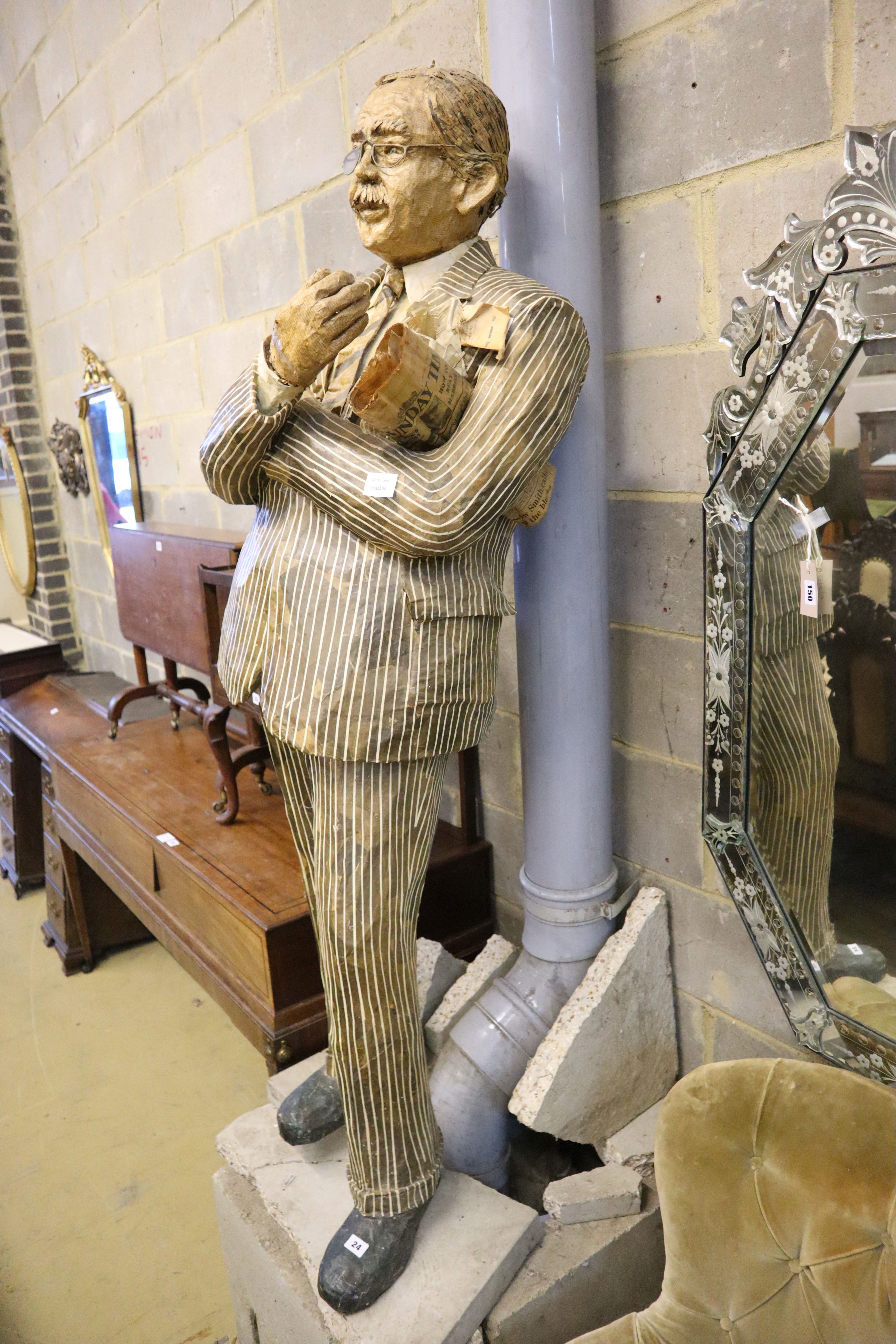 A stuffed papier mache figure of a gentleman holding the Sunday Times, height 170cm